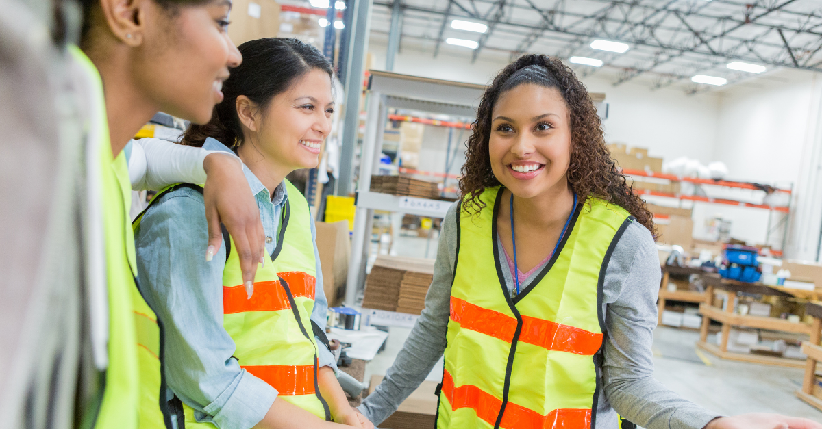 Three smiling female employees in yellow vests - boost employee motivation