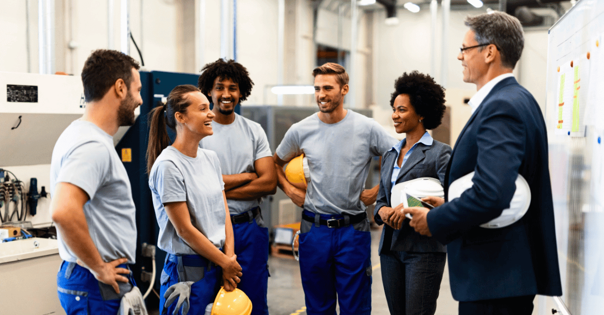 Employees with hardhats gathered around and smiling - employee retention strategy