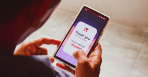 Person holding phone with onscreen message reading "Thank you for your order. You've earned 50 points!" - What is a channel incentive program?
