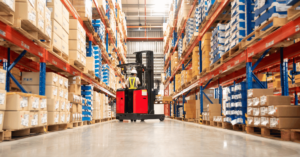 Person driving red forklift down warehouse aisle - dealer incentive program