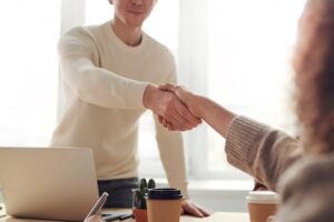 Two people shaking hands over desk - partner engagement in B2B marketing