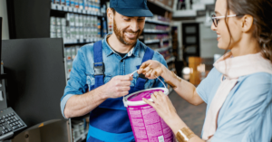 Man in blue overalls checking out woman holding pink bucket - measuring customer loyalty