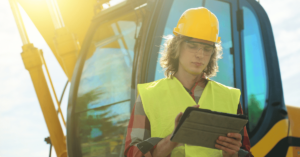 Young man in yellow hard hat using a tablet - Using omni channel marketing to increase construction revenue