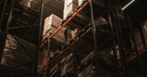 Boxes sitting on shelves in the back of a shadowy warehouse - Clearing Obsolete Inventory with Smarter Incentives and Stronger Marketing