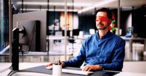 Man in office setting using computer blindfolded - The Open Secret in B2B Marketing is No One Knows What's Working or Why