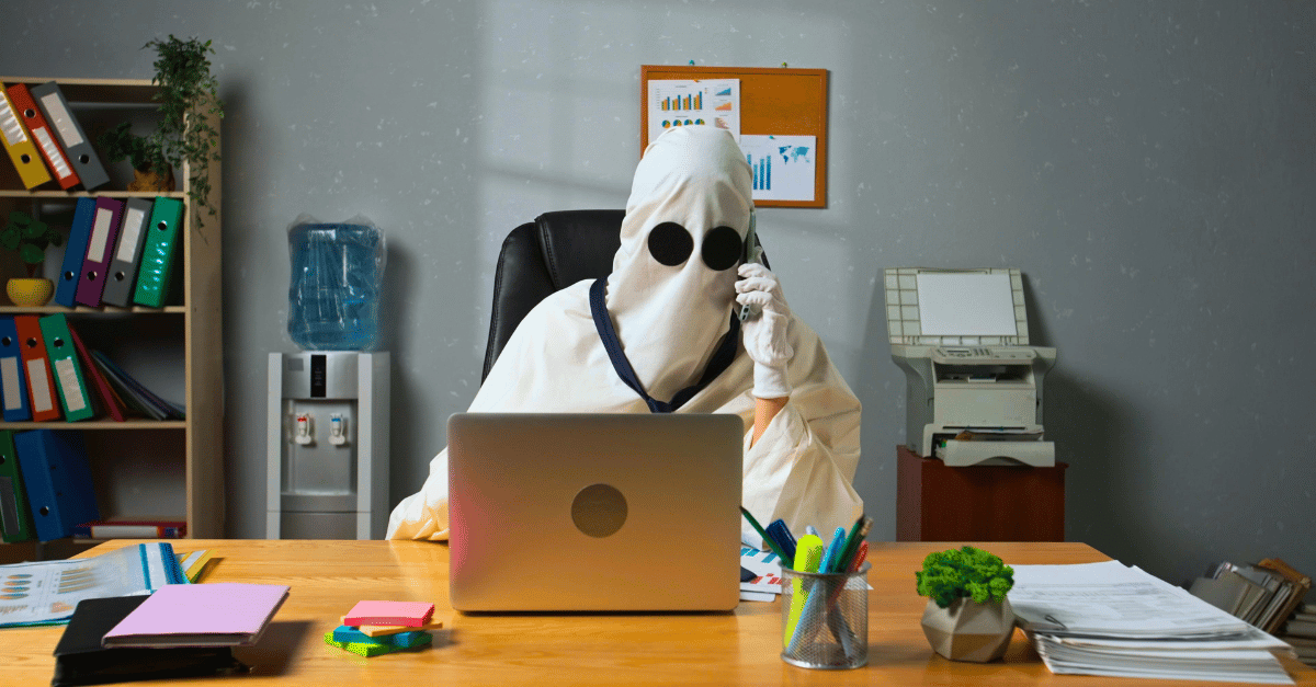 Person at desk with laptop and phone, wearing ghost costume - Ghosted by Channel Partner? Here's Why You Didn't See It Coming